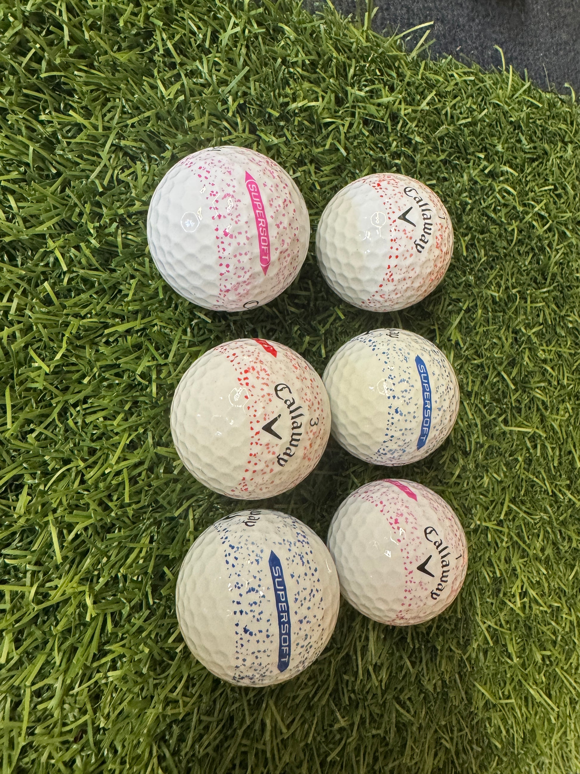 callaway super soft splatter golf balls displayed on turf. 